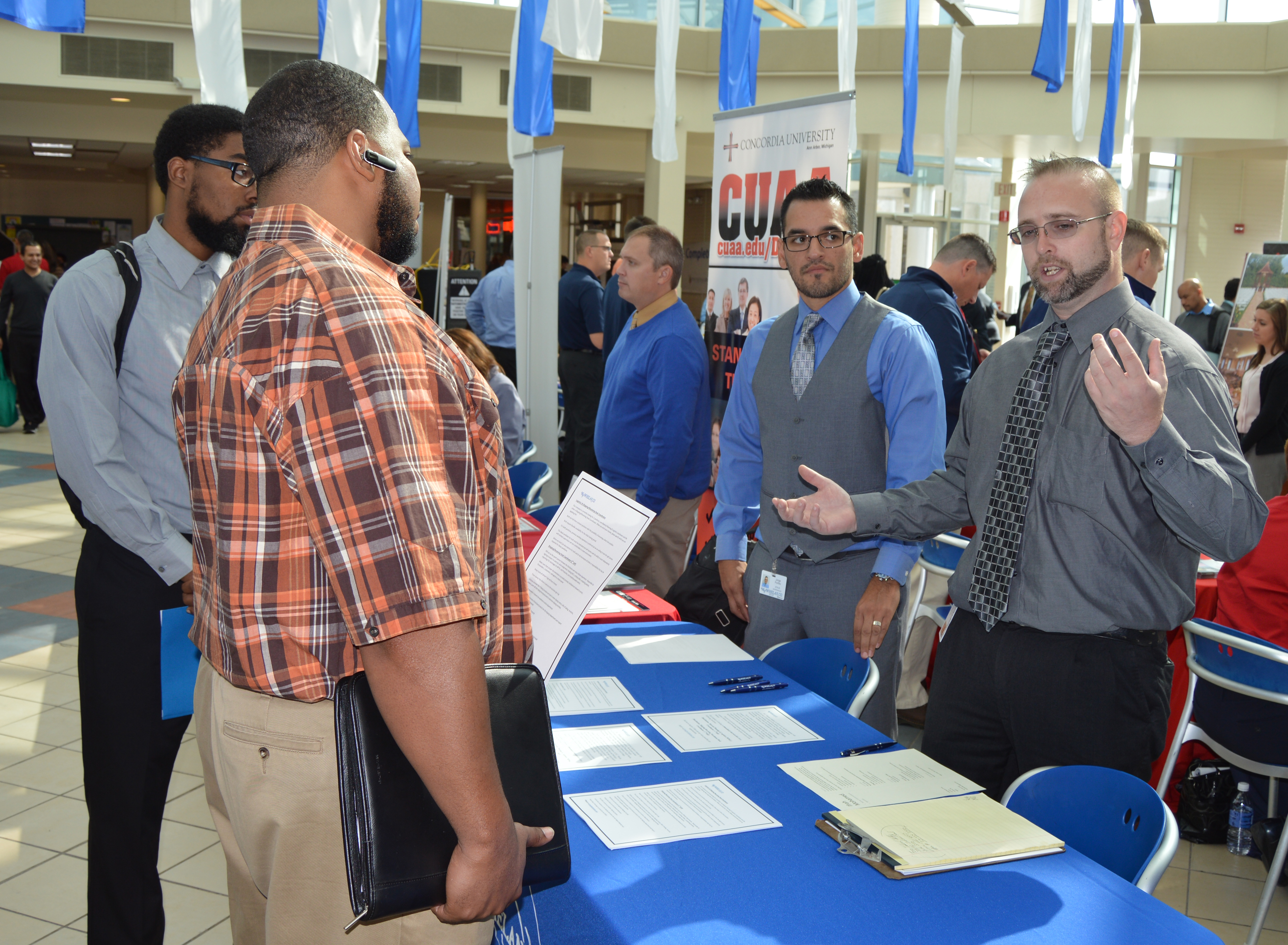 Two men talking to employers at career fair