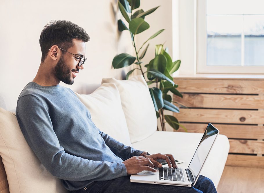 Student sitting on a couch looking at career information on a laptop